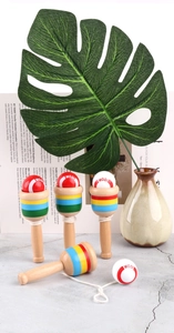 Detailed close-up of wooden Kendama toys with colorful stripes and red white spheres