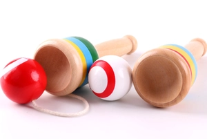 Close-up of wooden Kendama cup-and-ball toys with colored rings and patterned balls
