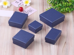 Deep blue jewelry box set with linen texture showing various sizes on a wooden desk