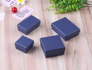 Detailed view of dark blue textured jewelry boxes in various sizes on light wood background