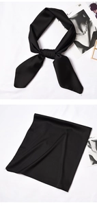 Detail of elegant black satin scarf showcasing silk-like luster and knotted styling