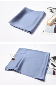Detail of gray blue silk satin square scarf with soft glossy texture and elegant folds