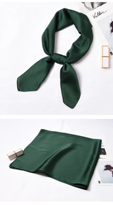Close-up of deep forest green silk square scarf with glossy satin finish and smooth texture