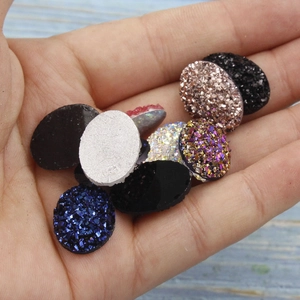 Oval and round mixed color resin crystal druzy charms held in palm for jewelry making