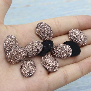 Macro view of 13x18mm oval resin flatback stones with sparkling glitter druzy texture