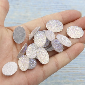 Macro shot of 13x18mm oval resin druzy cabochons with white glitter finish for DIY jewelry