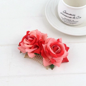 Detailed view of dual velvet red rose bridal hair comb with elegant golden metal base
