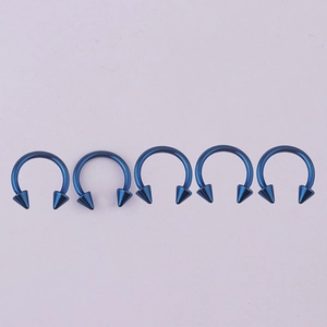 Row of five blue 316L stainless steel horseshoe rings with spiked cone ends