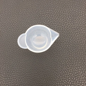 Close-up of translucent silicone mixing cup with pour spout and handle for DIY resin art