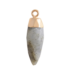 Macro shot of grey natural agate crystal bullet pendant with golden metal cap details