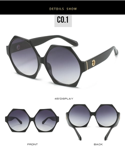 Detail of black hexagonal sunglasses featuring gold metal buckle and gradient lenses
