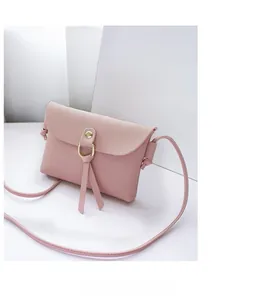 Detail of pink PU leather mini crossbody bag with gold ring and tassel decoration