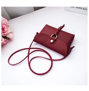 Vista dettagliata di una mini borsa a tracolla bordeaux da donna con anello dorato chic