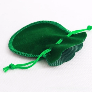 Detail of green velvet drawstring jewelry pouch with reinforced stitching and woven cord