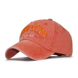 Close-up of coral orange washed cotton baseball cap with 3D New York embroidery detail