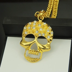 Hiphop-Goldkette mit Totenkopf-Anhänger und klaren Strasssteinen auf goldener Kordelkette
