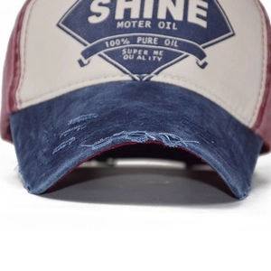Close-up of distressed brim and industrial logo on a vintage cotton baseball cap