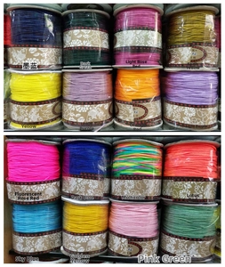 Detailed grid display of sixteen colorful spools of nylon cord for DIY jewelry braiding