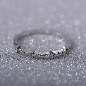 Macro detail of silver ring featuring four delicate sparkling pavé zircons on thin band