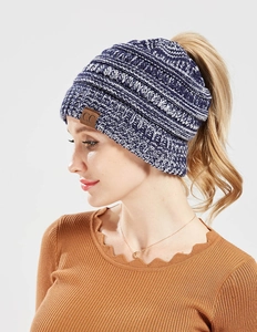 Detailed close-up of navy and white knit ponytail beanie with a C.C leather patch