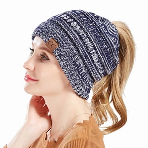 Detail of knit ponytail beanie with blue white pattern and leather C.C brand label