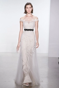 Close-up of elegant white lace dress with a decorative black floral waist belt detail