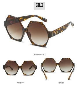 Detail view of hexagonal tortoiseshell sunglasses with brown gradient lenses and gold accents
