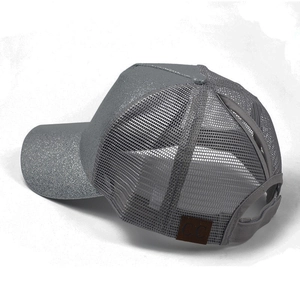 Detail view of the criss-cross elastic ponytail hole on a glitter mesh baseball cap