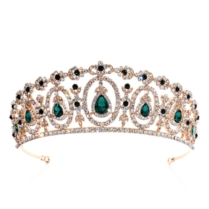 Macro view of bridal crown detailing green crystals and gold filigree on white background