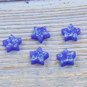 Macro view of blue star-shaped opal resin beads with glitter effect and 1.5mm holes