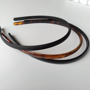 Detailed view of three 0.8cm plastic headbands in matte black, glossy black, and tortoiseshell