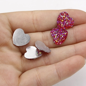 Macro-opname van 12 mm rode holografische hart-harsstenen in een handpalm voor schaal