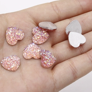 Detailopname van roze glitter hartvormige hars cabochons met zilveren platte kant