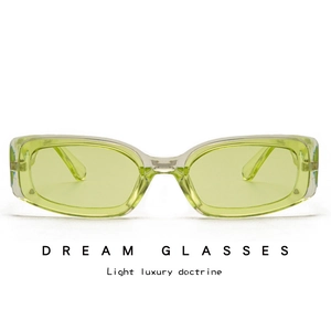 Detail view of rectangular sunglasses with light green lenses and transparent frames