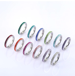 Detail view of 11 colorful stackable titanium steel rings with round crystal inlay