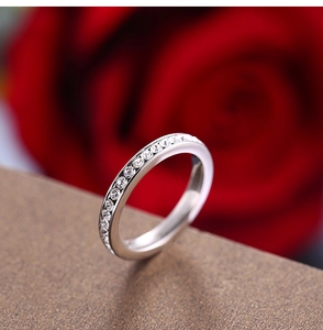 Macro detail of silver eternity ring with pavé-set round cubic zirconia and roses