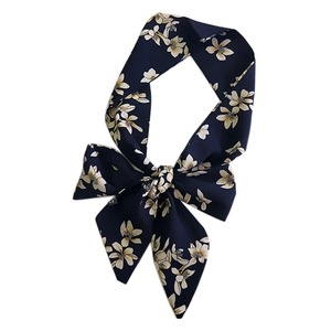 Floral print navy blue silk scarf tied in a bow knot on a clean white background