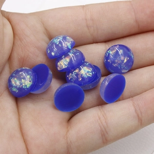 Macro shot of 12mm blue oval synthetic opal cabochons with iridescent foil for jewelry making