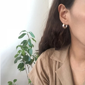 Close-up of geometric 925 sterling silver hoop earring worn on model for a modern look