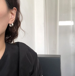 Side view of model wearing thick geometric 925 silver hoop earrings with a polished finish
