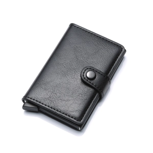 Detail of black lychee grain leather card holder with automatic pop-up button mechanism