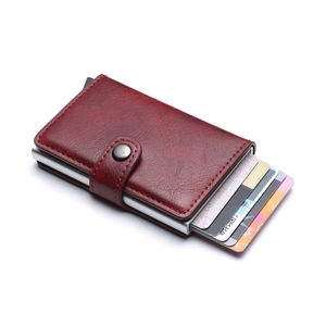 Detail view of red lychee leather card holder with pop-up aluminum credit card slot