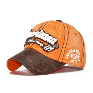 Detail of 3D embroidery and vintage distressed brim on an orange and brown baseball cap