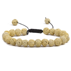 Close-up of beige porous stone beads on a black adjustable cord bracelet for men