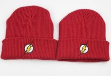 Detail of red knit beanies with yellow lightning bolt embroidery for streetwear style