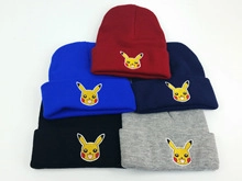 Flat lay of colorful knitted beanies featuring yellow Pikachu embroidery in five colors