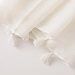 Detailed macro view of white semi-transparent scarf fabric with elegant tassel trim