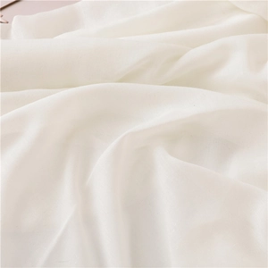 Close-up of white sparkling fabric with delicate glitter texture and soft draped folds