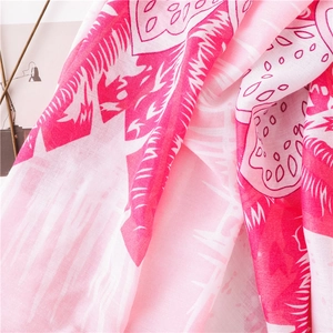 Gros plan d'une écharpe légère en coton et lin avec imprimé palmier rose et texture douce