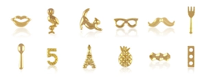 Macro shot of 12 mixed gold alloy nail charms including Eiffel tower and flamingo shapes